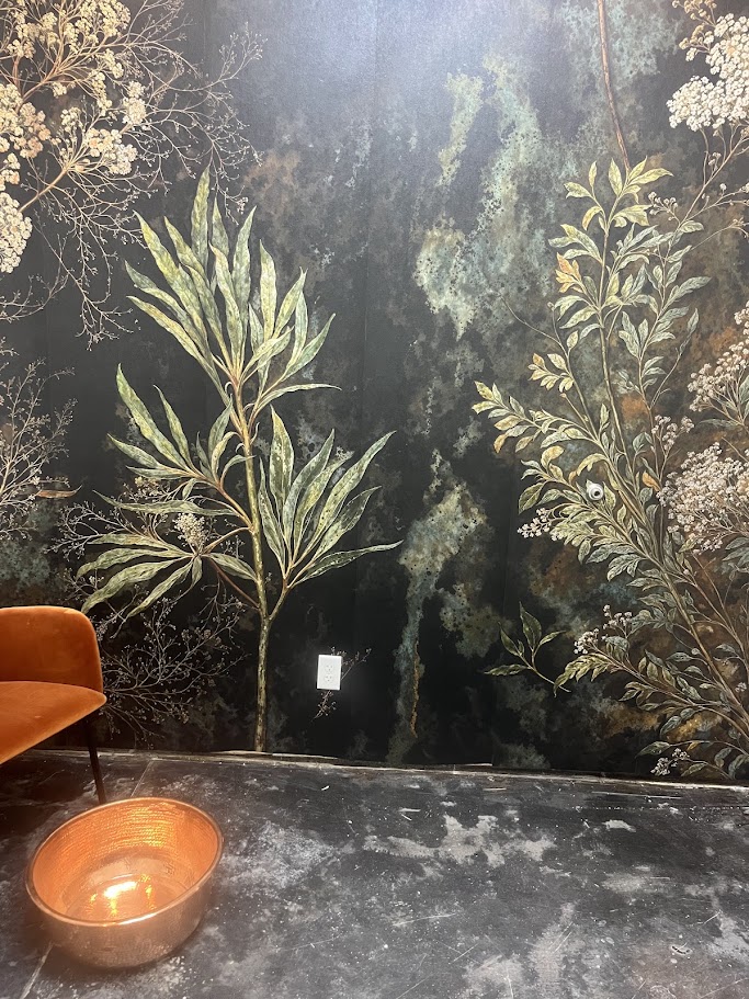 Botanical mural-style wallpaper with warm salon furnishings at Aveda Salon